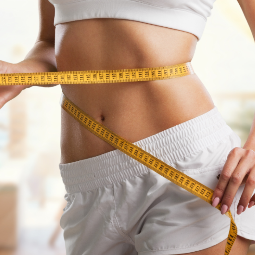 A fit woman measuring her waist.