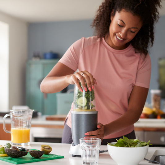 A happy woman making a healthy smoothie.