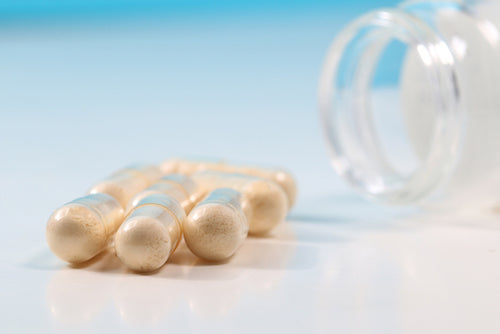 Group Of Transparent Probiotics Capsules And Glass Bottle Onthe White