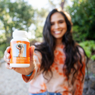 Kimberly Snyder holding Feel Good Digestive Enzyme supplements.