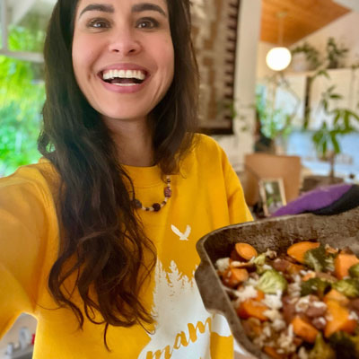 Kimberly Snyder holding a bowl of Balance and Flow Sweet Potato Casserole.