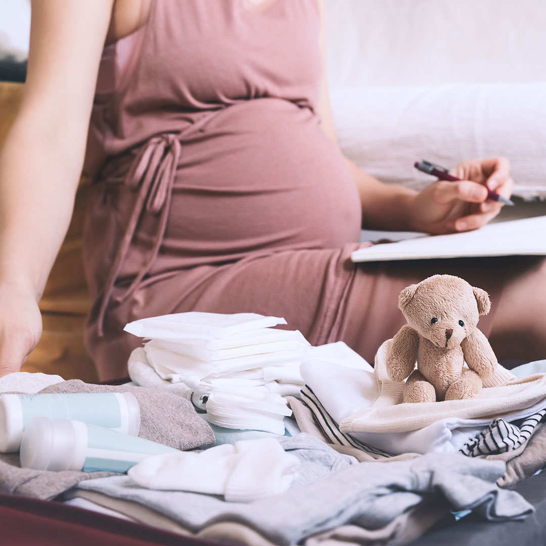 Pregnant woman making checklist for childbirth