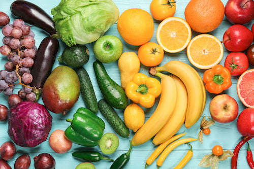 Creative composition made of fruits and vegetables in rainbow colors on wooden background, flat lay