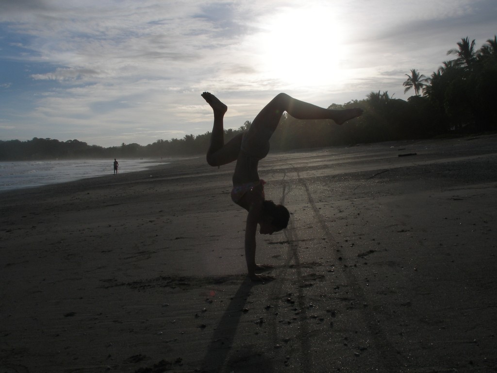 Image of Kimberly Snyder holding a yoga pose on the beach