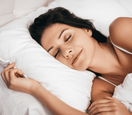 Brunette lady sleeping on white sheets & pillow