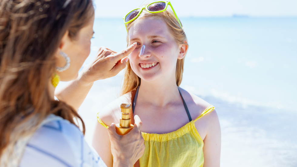 A woman applies sunscreen