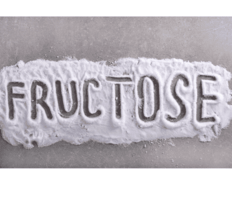 "Fructose" written with finger in a pile of sugar