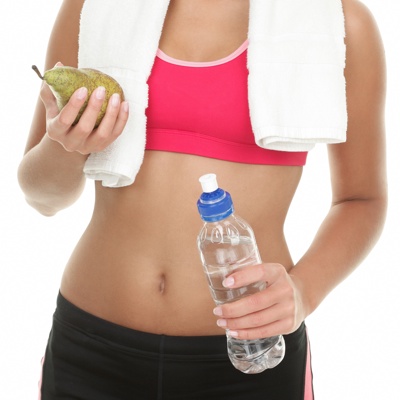 Athletic lady holding a water and a pear