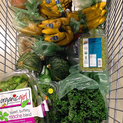 Picture of Kimberly's grocery cart full of greens and fruit.