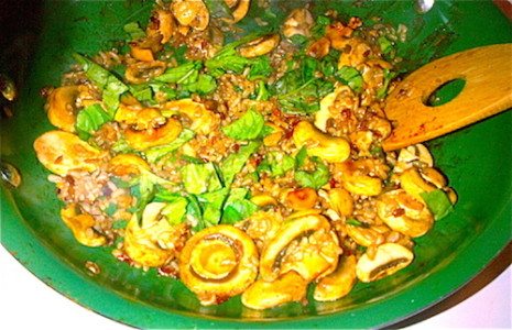 Picture of mushrooms being cooked in green nonstick pans