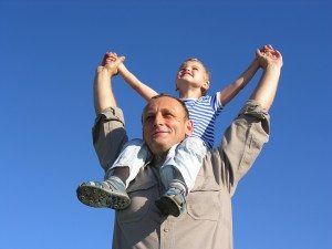 Picture of a dad holding his son on his shoulders