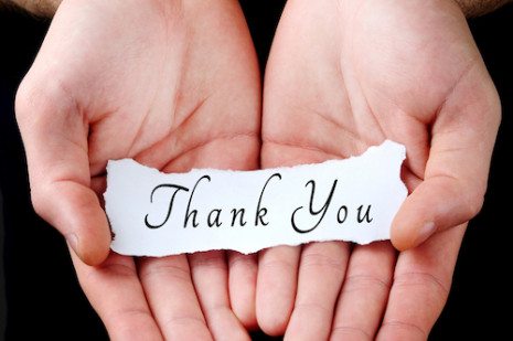 Picture of two hands holding a thank you note