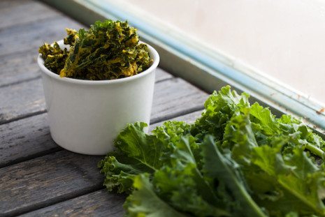 Picture of kale in a white bowl and on wooden table