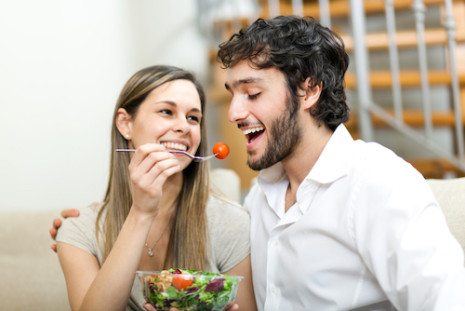 Picture of woman feeding a man salad