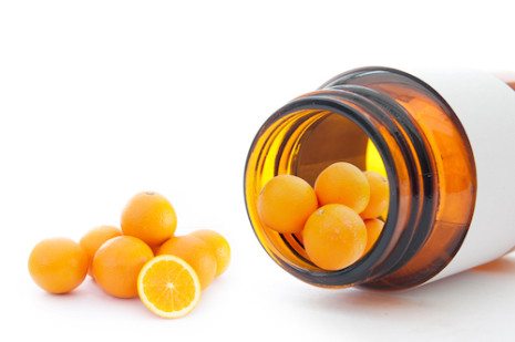 Picture of vitamin bottle with little oranges falling out like vitamins