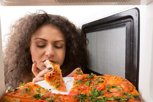 Picture of female reaching for pizza
