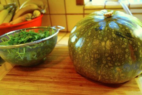 Picture of a whole kabocha squash and greens