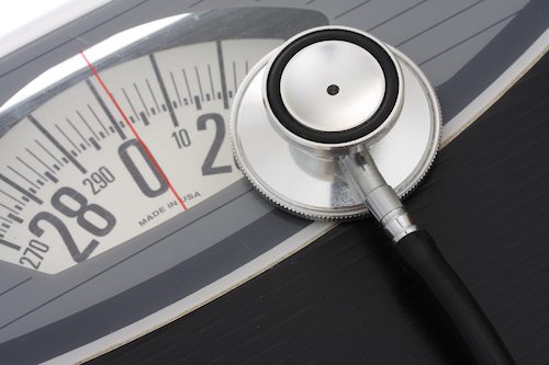 Close up of stethoscope on a weight scales.