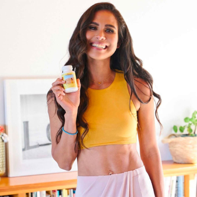 Kimberly standing and holding a bottle of SBO+ Probiotics.