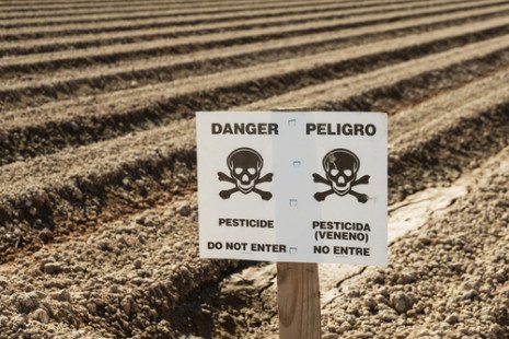 Picture of crop field with Danger Pesticide sign
