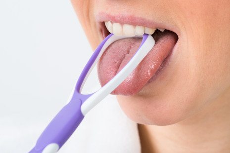 Close-up Of A Woman Cleaning Her Tongue