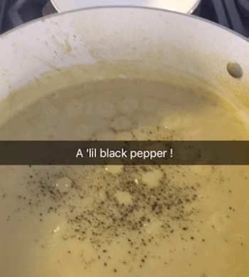 Picture of the soup in a pot warming up and pepper sprinkled in