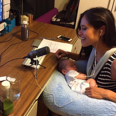 Picture of Kimberly holding Emerson on her lap while recording podcast show