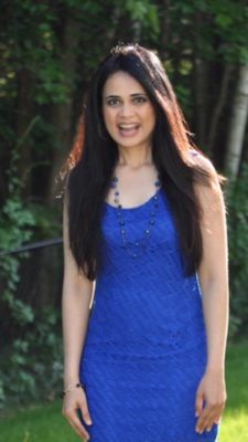 Picture of Ramya in a blue dress standing outside
