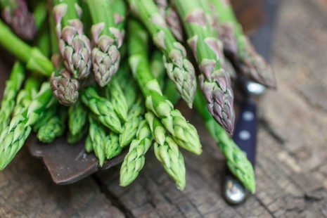 Picture of fresh green asparagus on old wooden table. 