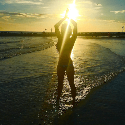 Picture of Kimberly doing a yoga pose at sunset on the beach.