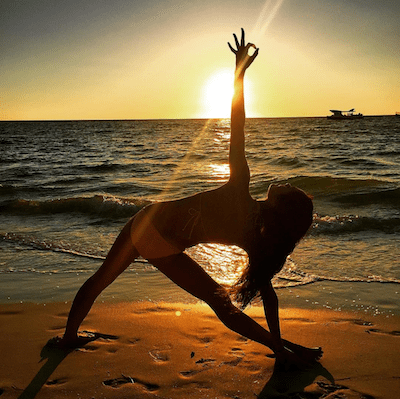 Ditch New Year's resolutions for good! - Image of Kimberly holding a yoga pose on the beach