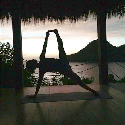 Picture of Kimberly doing yoga outside, at sunset.