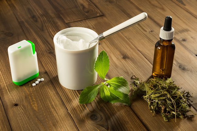 White tablets and green leaves of natural sweetener stevia.