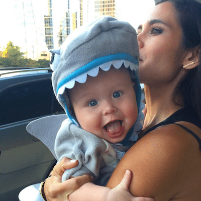 Kimberly holding Lil Bub wearing a shark costume.