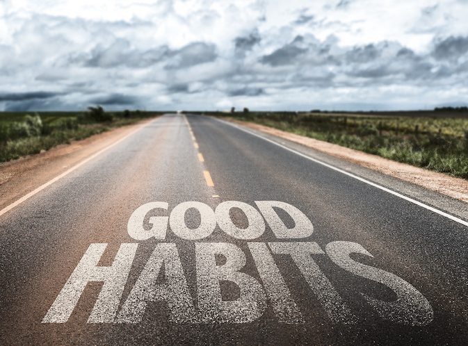 Picture of the words, "Good Habits" written on a rural road.