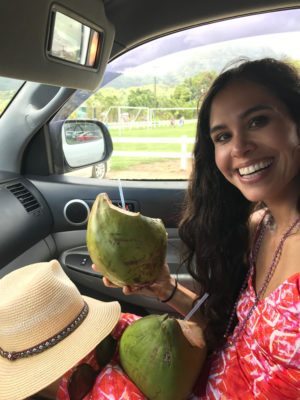 Picture of Kimberly holding a piece of fruit in the car. 