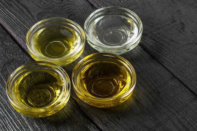 Different types of vegetable oil of vegetable mustard and sesame seed walnut grape seeds in glass bowls. It is used in dietary and healthy nutrition. Source of vitamins polyunsaturated fatty acids