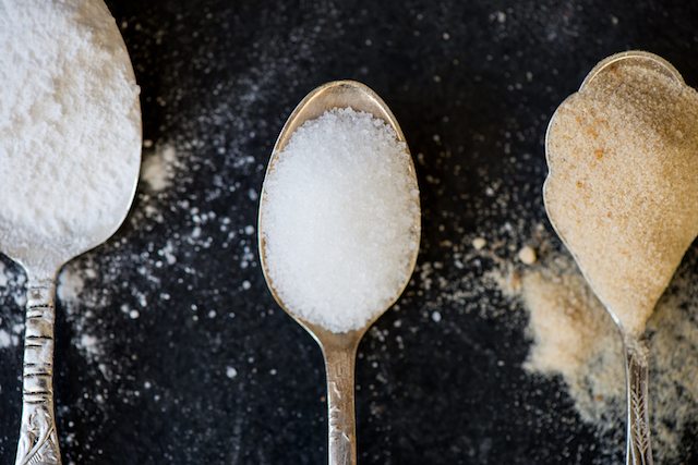 Different Kinds of Sugar in the Spoons such as coconut sugar pure cane sugar icing sugar agave syrup dark brown soft sugar golden caster sugar demerara cubes