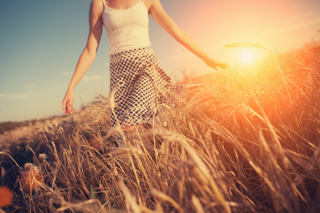 A Blurred Girl Running Through The Wheat Field At Sunset (intentional Sun Glare, Lens Focus On Wheat