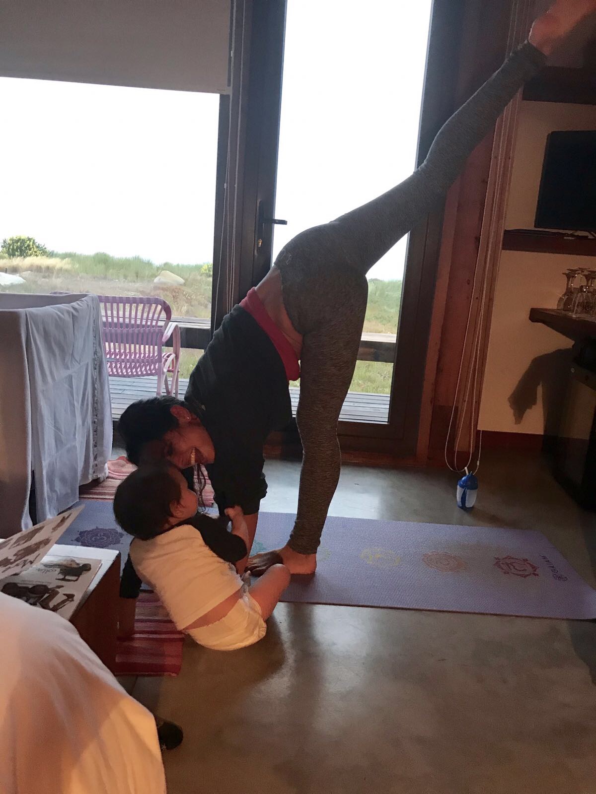 Picture of Kimberly doing yoga with Lil Bub playing nearby.
