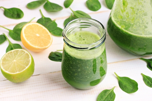 Green fresh leafy greens smoothie in glass jar, spinach leaves, lime, lemon. Refreshing healthy drink.