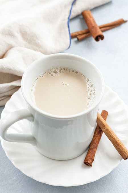 Nighttime Lavender Elixir in a white mug with cinnamon sticks