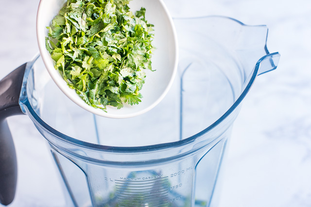 Adding cilantro and mint to blender
