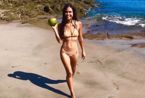 Kimberly Snyder holding a coconut on the beach
