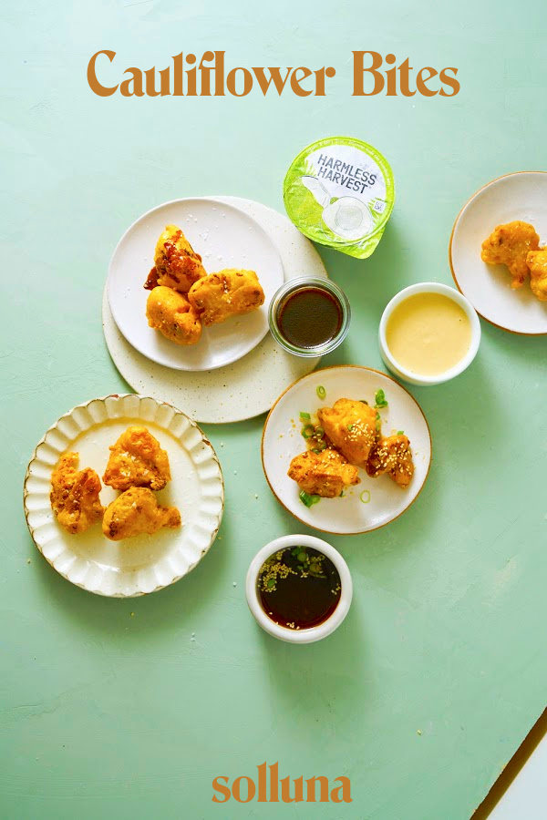 Cauliflower bites arranged on table with three different sauces.