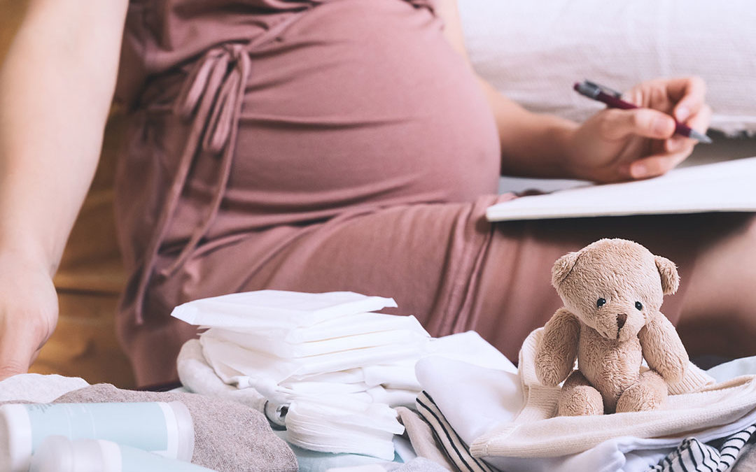 Pregnant woman making checklist for childbirth