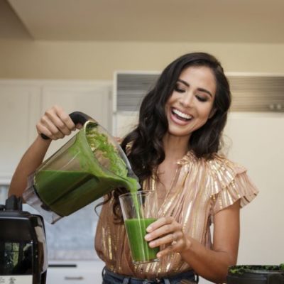 Kim pouring a glowing green smoothie.