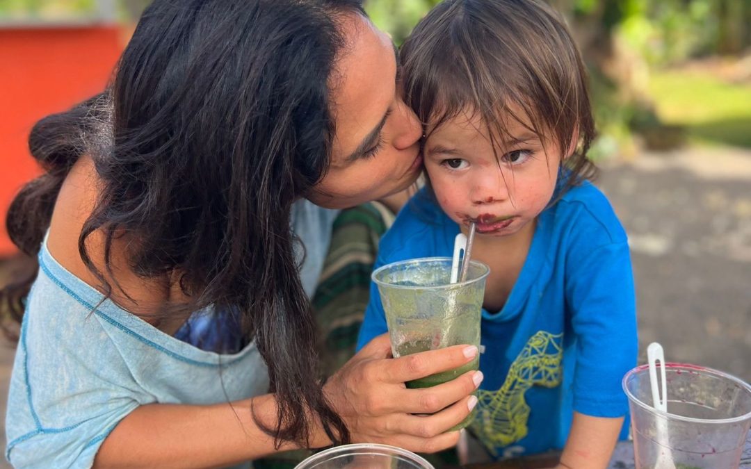 Kimberly drinking a Glowing Green Smoothie with her son Moses