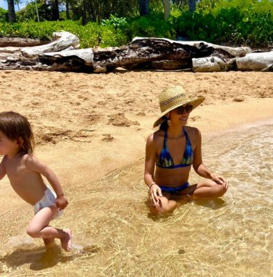 Kimberly at the beach in Hawaii with her son Moses running on the sand