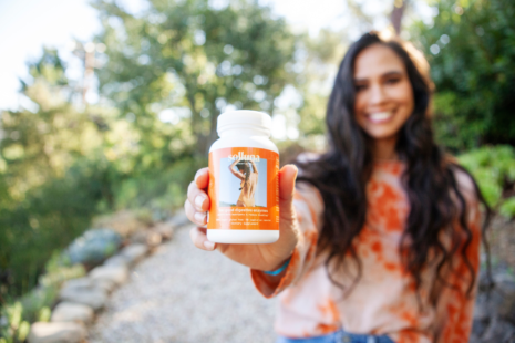 Kimberly Snyder holding Feel Good Digestive Enzyme supplements